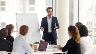 man at board speaking to people