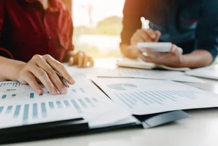 Close-up of people analyzing data on paper