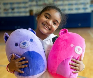 girl snuggling squishmallows